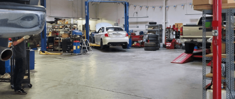 Indoor car service and garage where the image shows that cars being placed on repairing tracks for repair